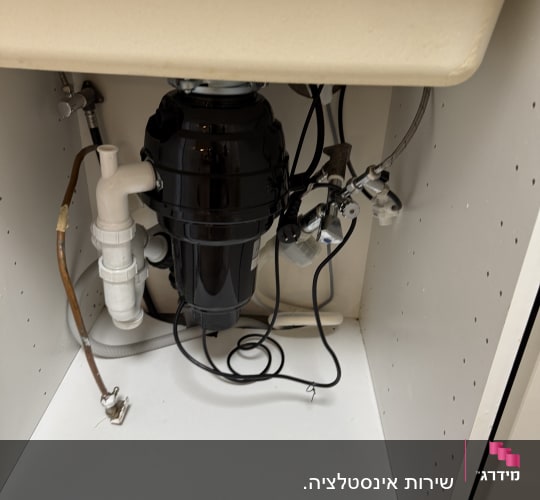 מתקן מתחת לכיור עם צינורות וחיבורים